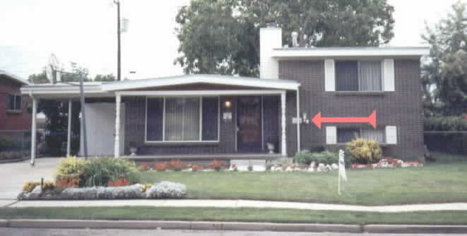 Real Estate Photo at time of sale to trusting young Thaxton family -- Notice the furnace exhaust out front east side of home below bedroom window, adjacent to family room window, front door -- and right next to the fresh air intake (square grill, behind drain pipe) to allow fumes to enter into home!